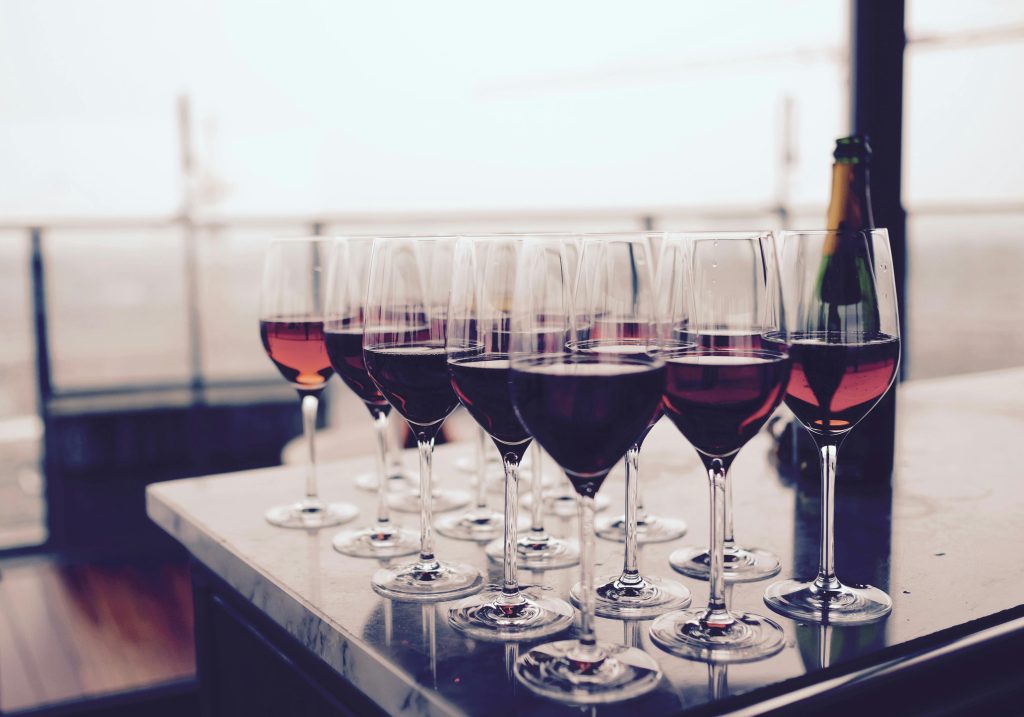 pexels-photo-66636-66636 A collection of red wine glasses elegantly arranged on a bar table, perfect for events.